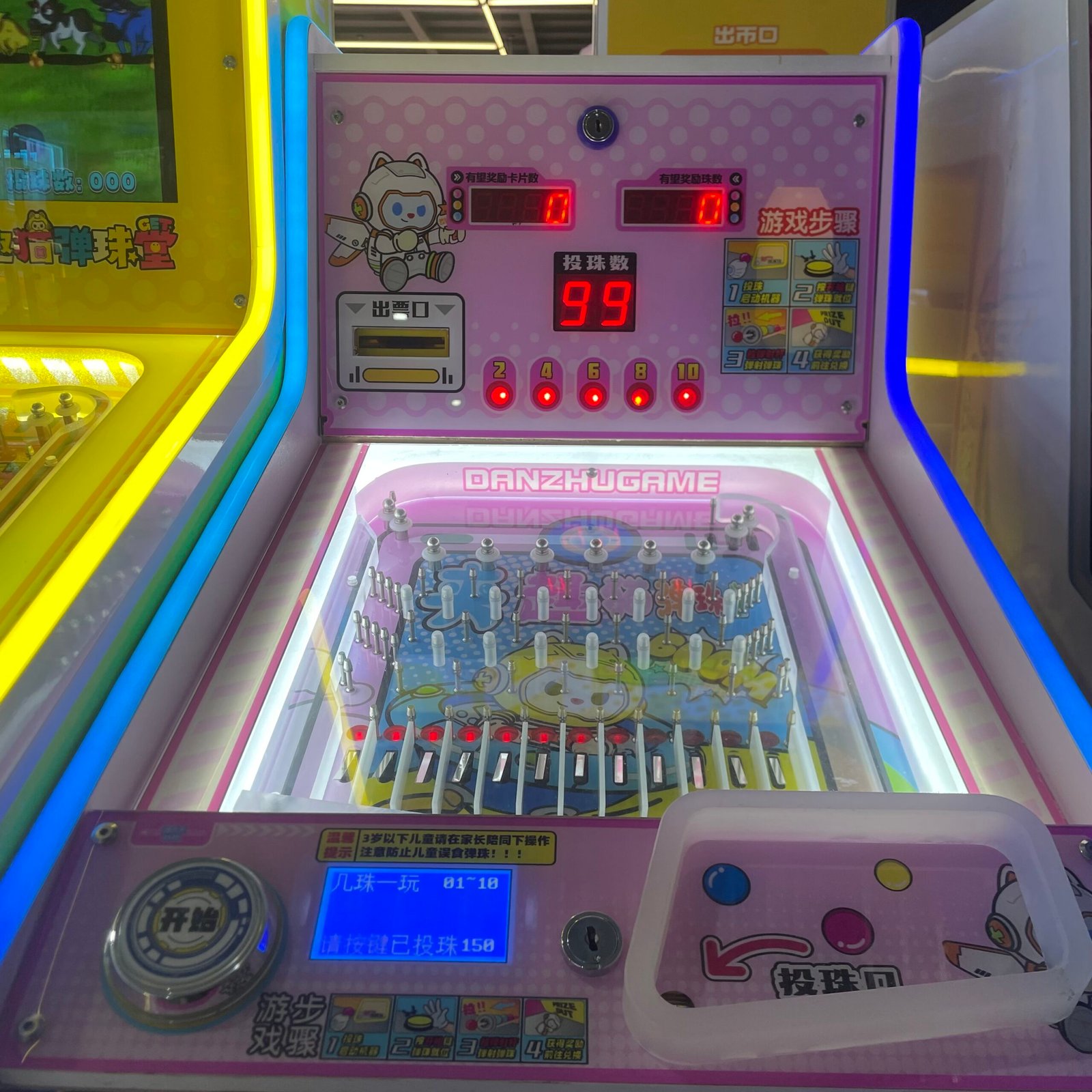 Arcade pinball machine gameplay board with ball dropping pins and scoring channels