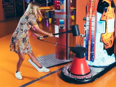 Couple looking at arcade claw machine thoughtfully, questioning whether the game is fair